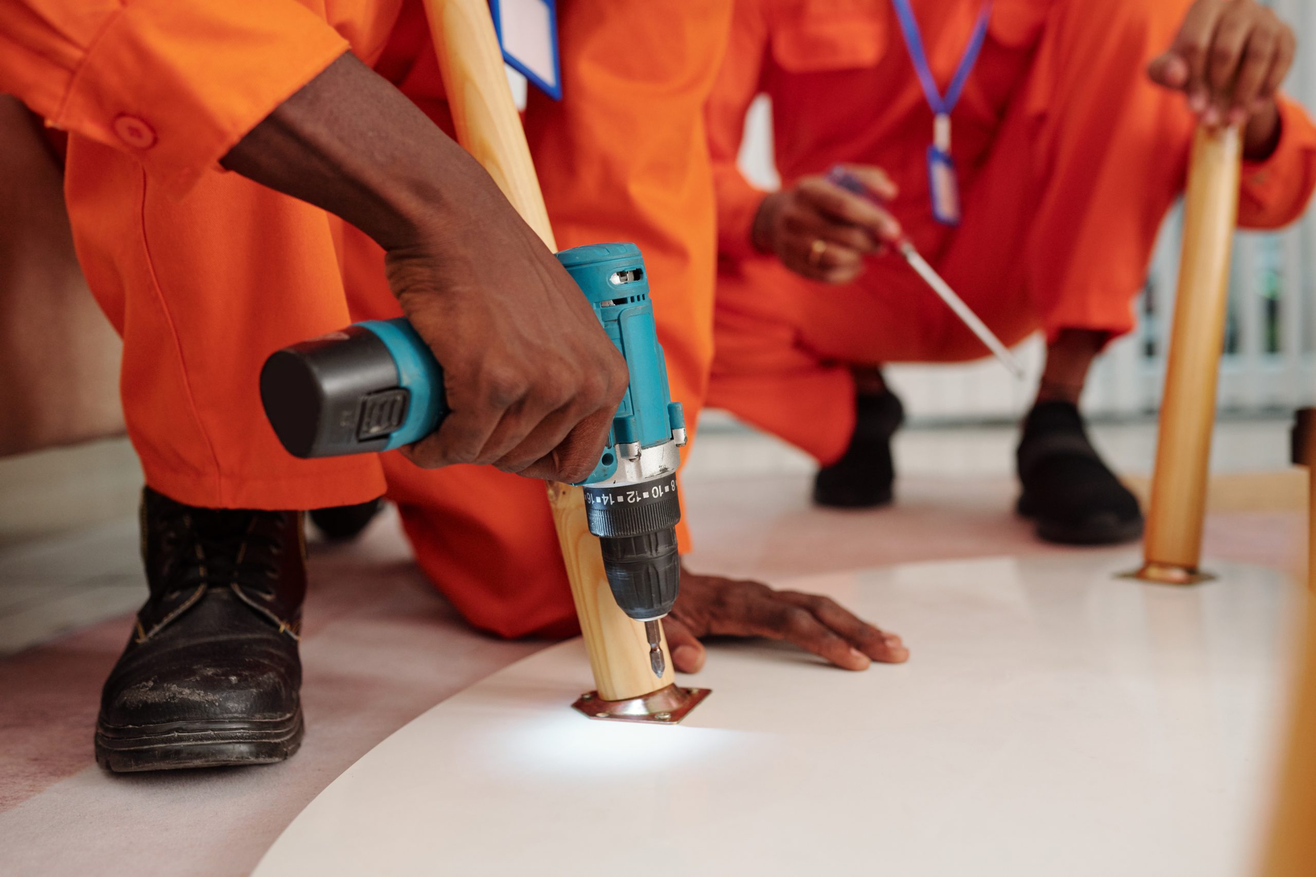 Black man installing screw into table