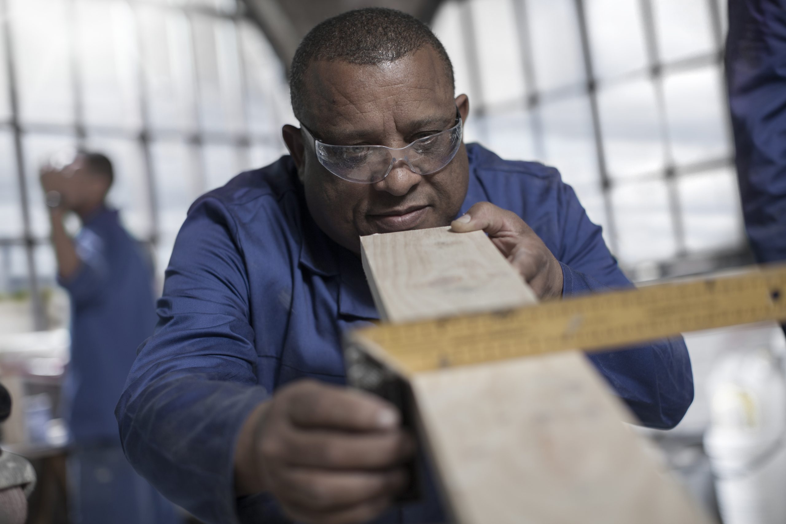 Carpenter measuring angle of plank in workshop