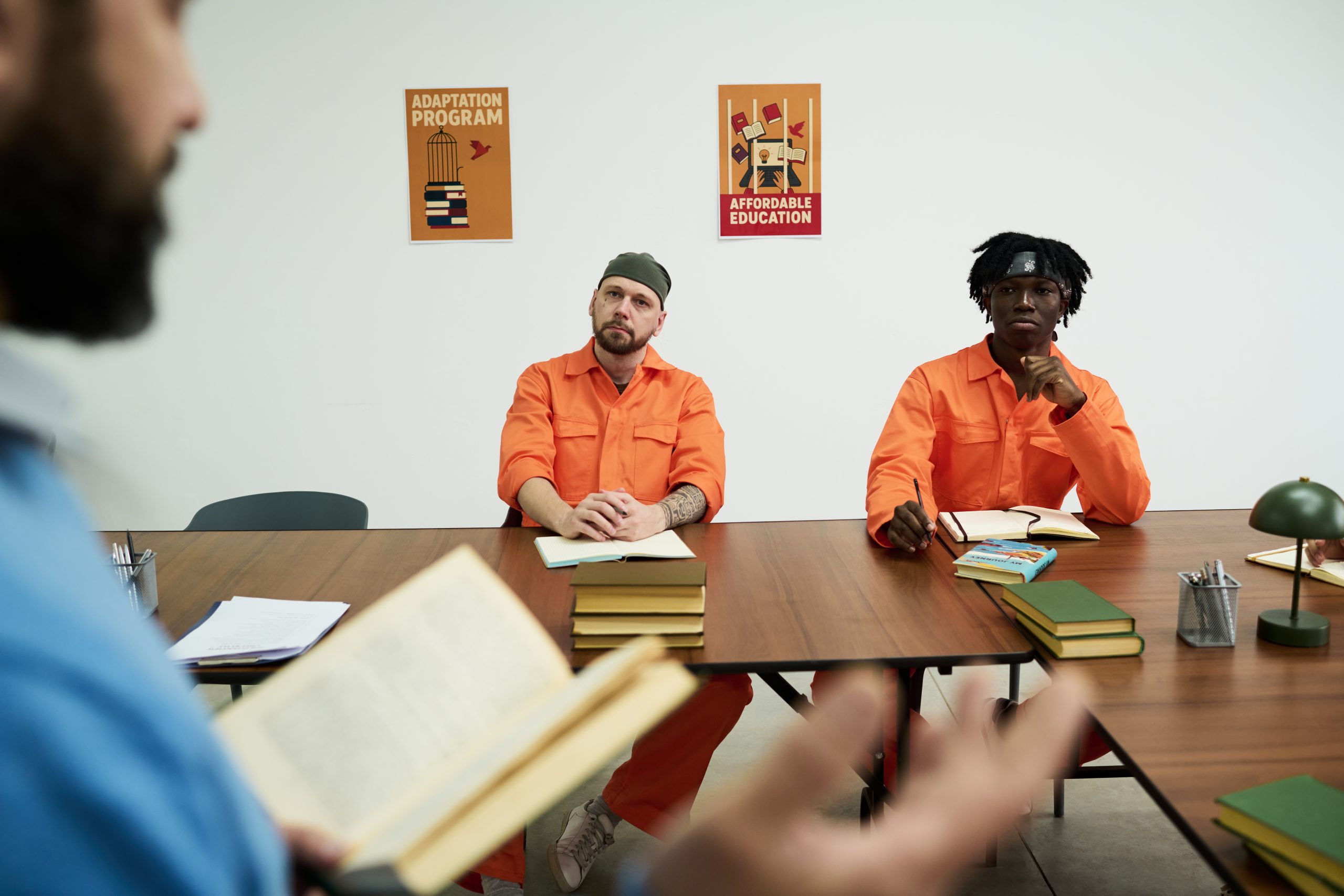 Caucasian Man and Black Man Listening to Instructor during Prison Education Program